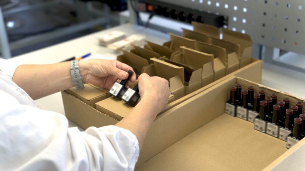 Pracovníčka DvS Pack pri ručnom balení kozmetických produktov do prepravných boxov